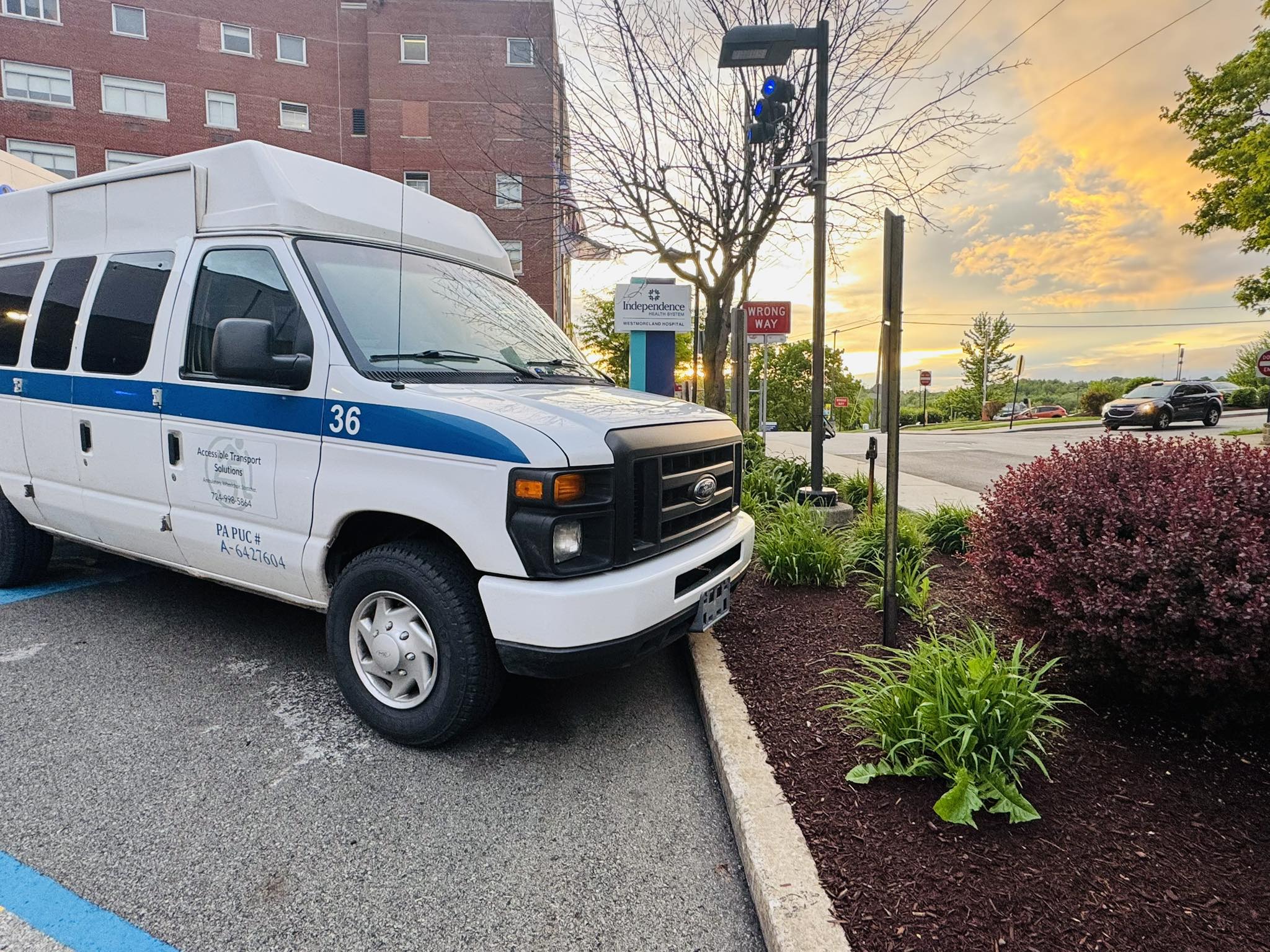 ATS wheelchair van parked outside a hospital at sunset